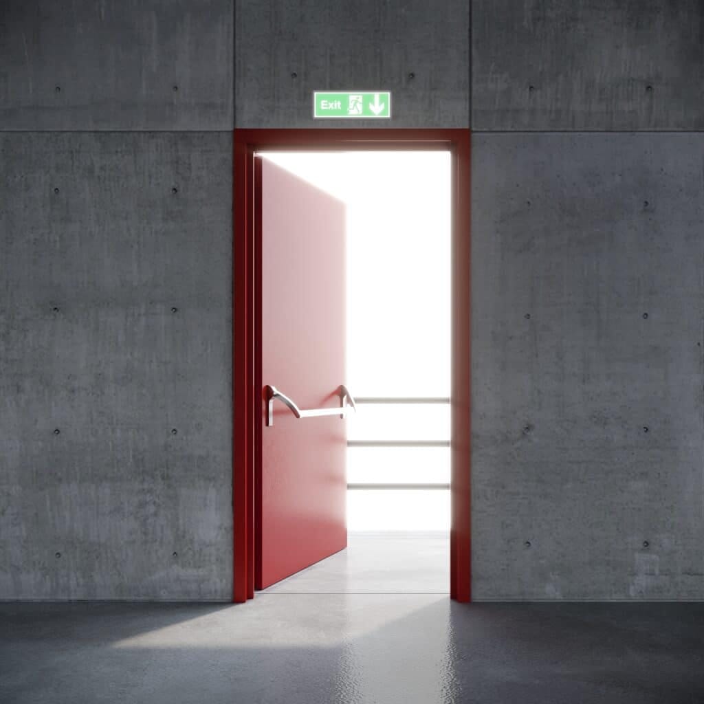 pintu baja berwarna merah dengan tanda exit